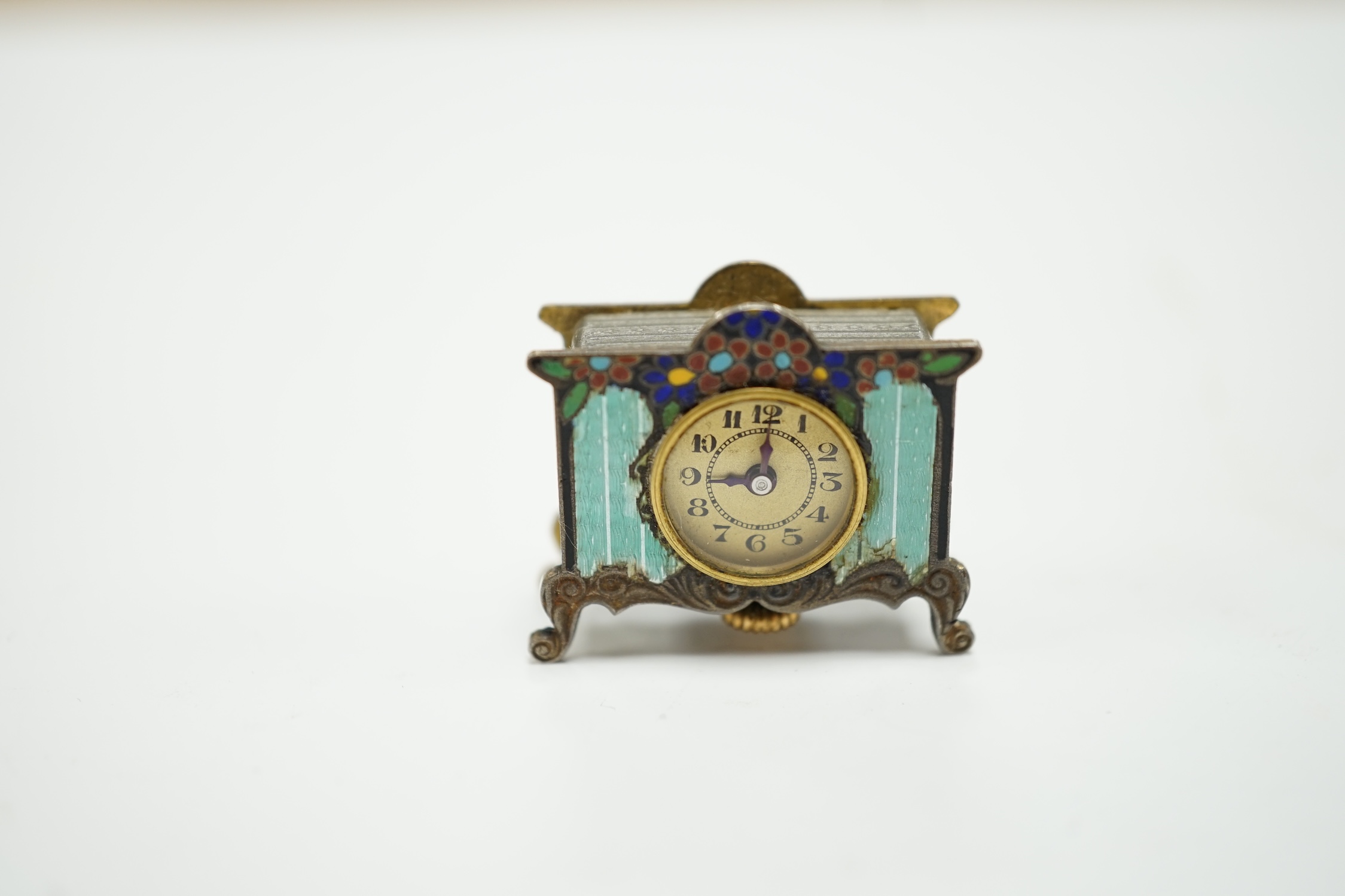 A miniature enamel timepiece modelled as a mantle clock, with watch movement, 2cm high, in fitted case